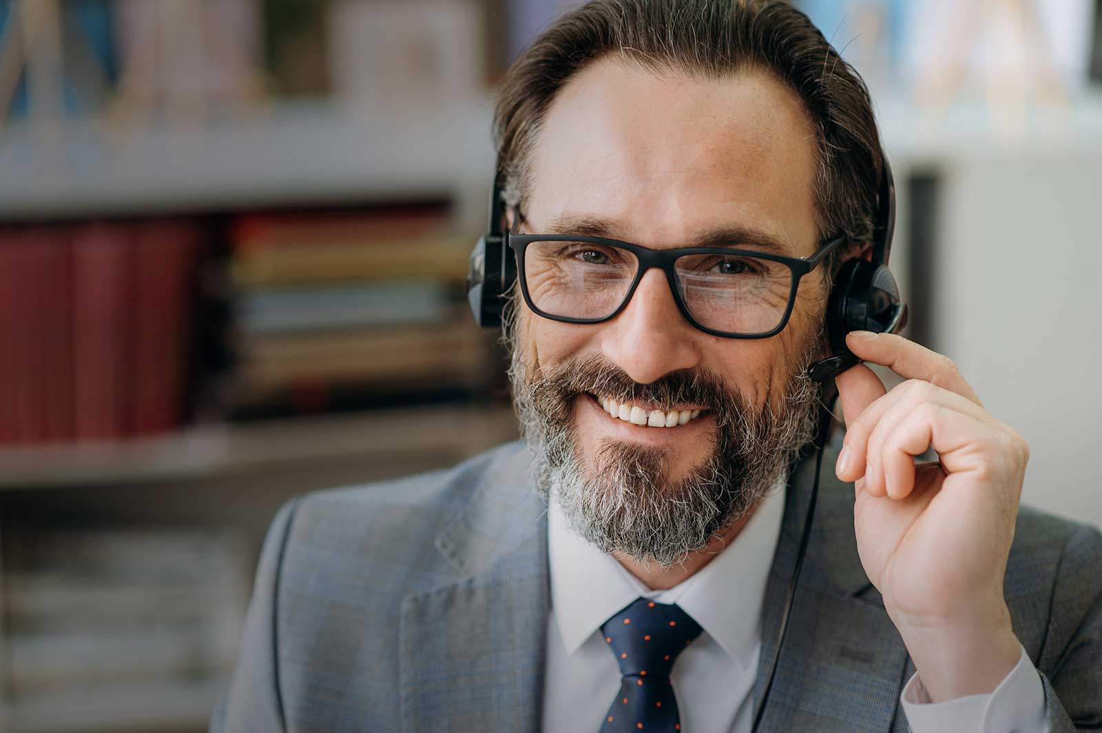 Glad medelålders man talar med headset.