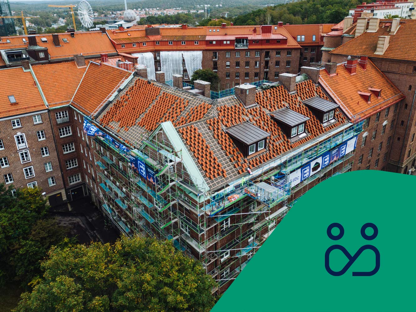 Vy över bostadshus med pågående takomläggning. Styrelseikon.