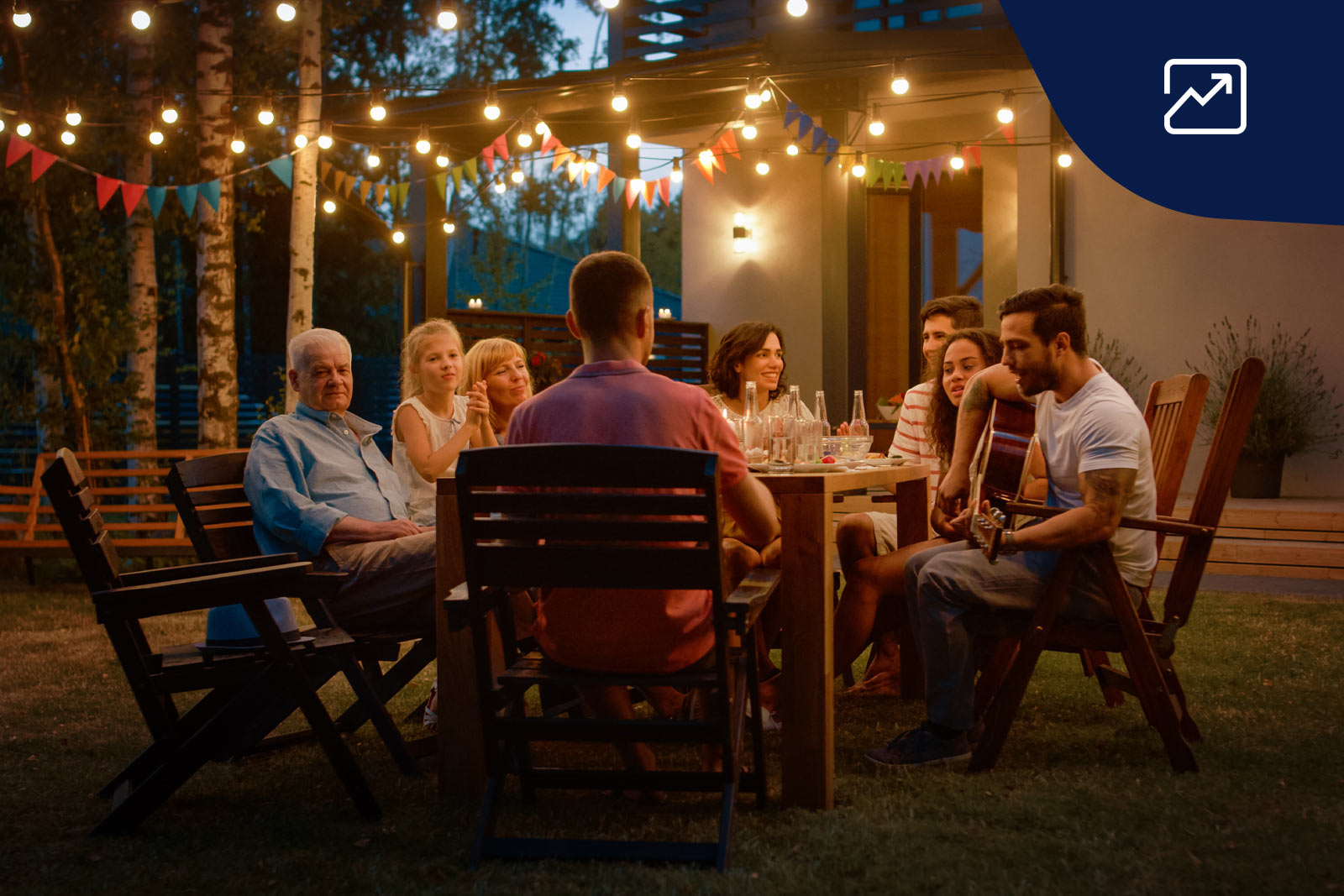 en grupp personer samlade runt ett bord utomhus en sommarkväll