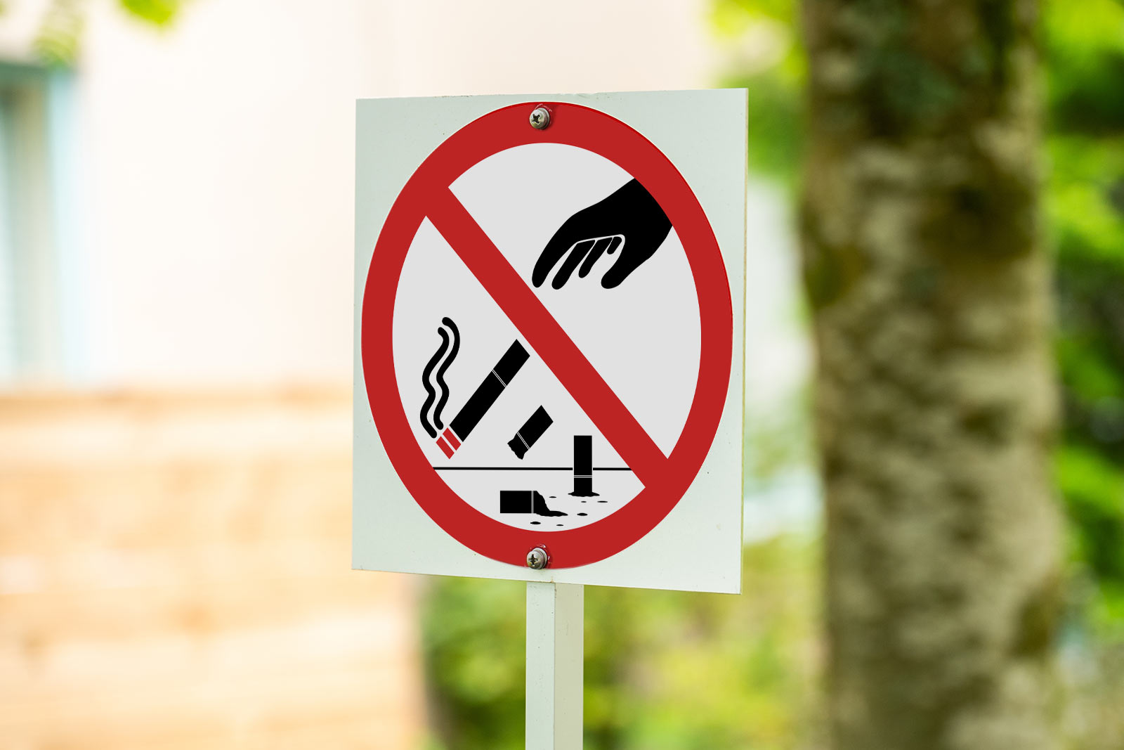 Skylt med ett rött streck över en hand som kastar cigarettfimpar.