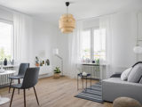 Vardagsrum med soffa, litet bord och vita gardiner