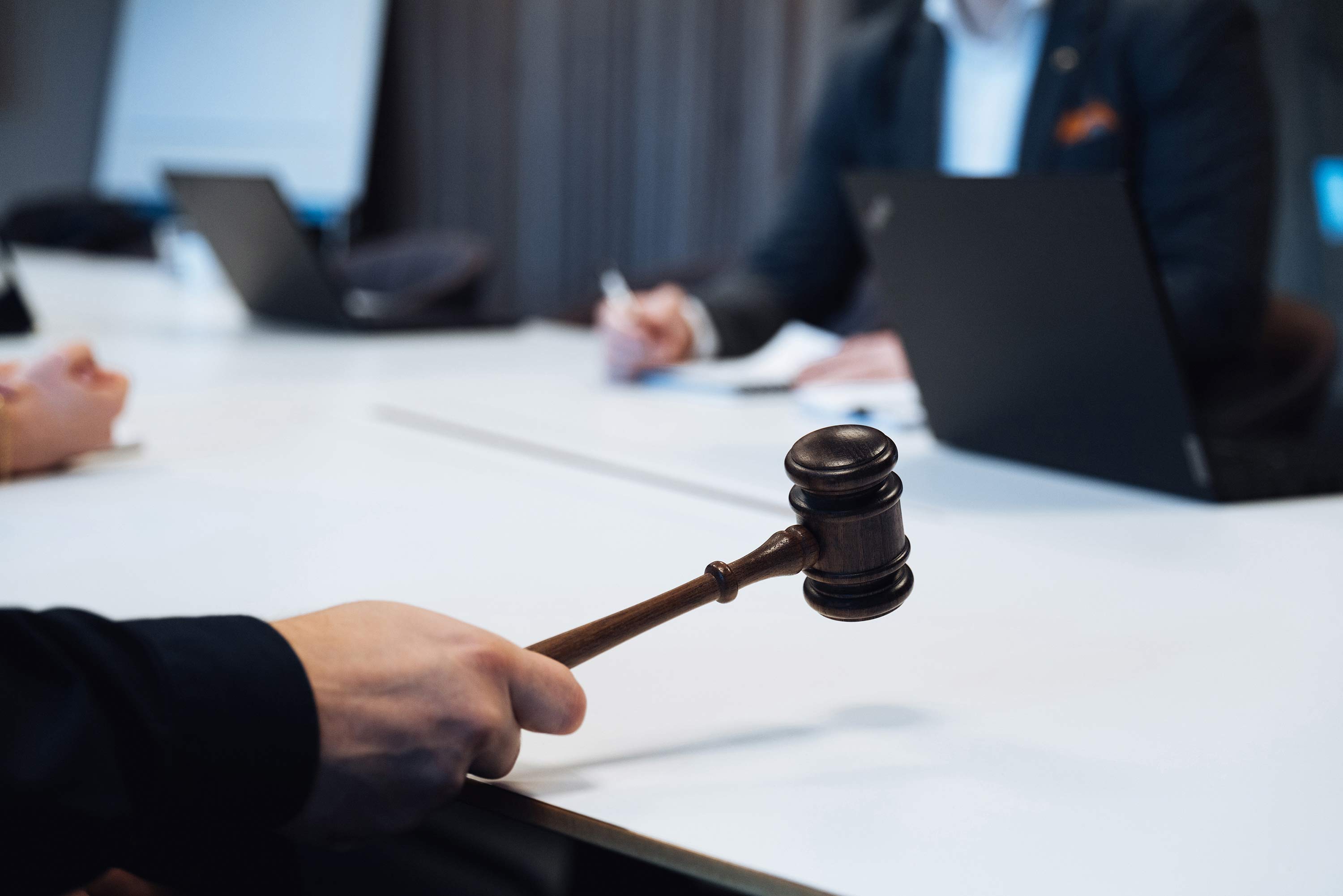 Hand som håller i domstolsklubba