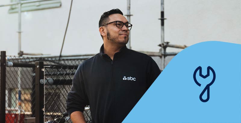 SBCs fastighetsskötare Gonzalo utanför en brf. Fastighetsservicesikon.