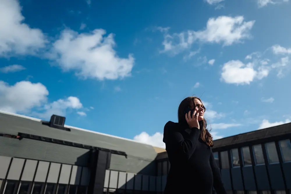 Josefine, Ekonomisk förvaltare på SBC, pratar i mobiltelefonen utomhus.