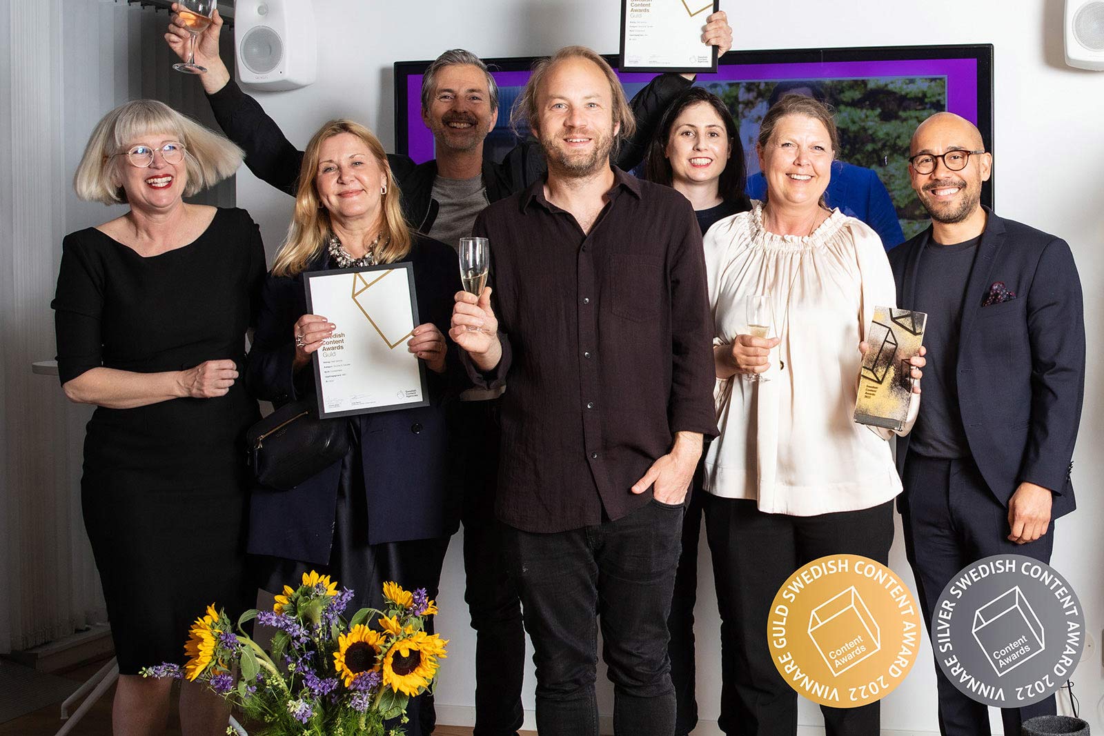 Medarbetare på SBC och externa konsulter håller upp pokaler och diplom