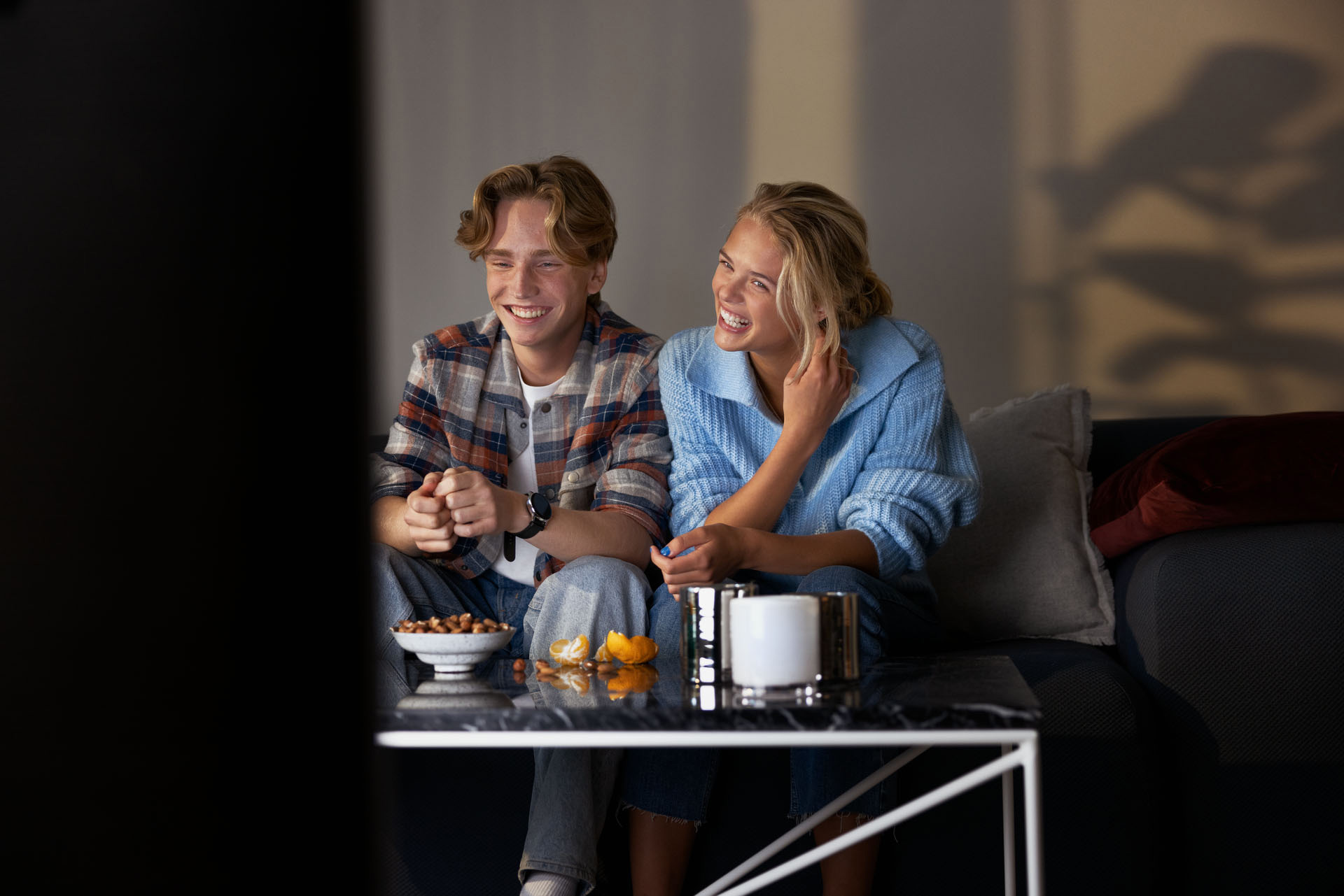 Två tonåringar skrattar framför tvn