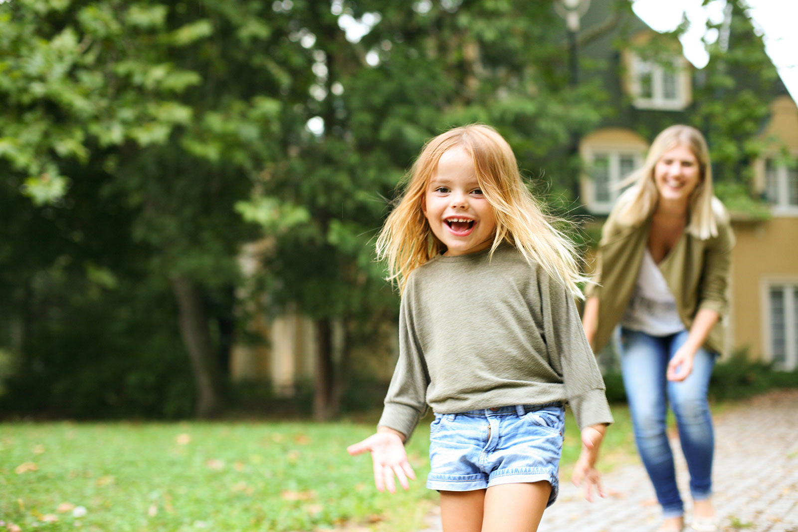 Mamma och dotter leker på innergård i brf