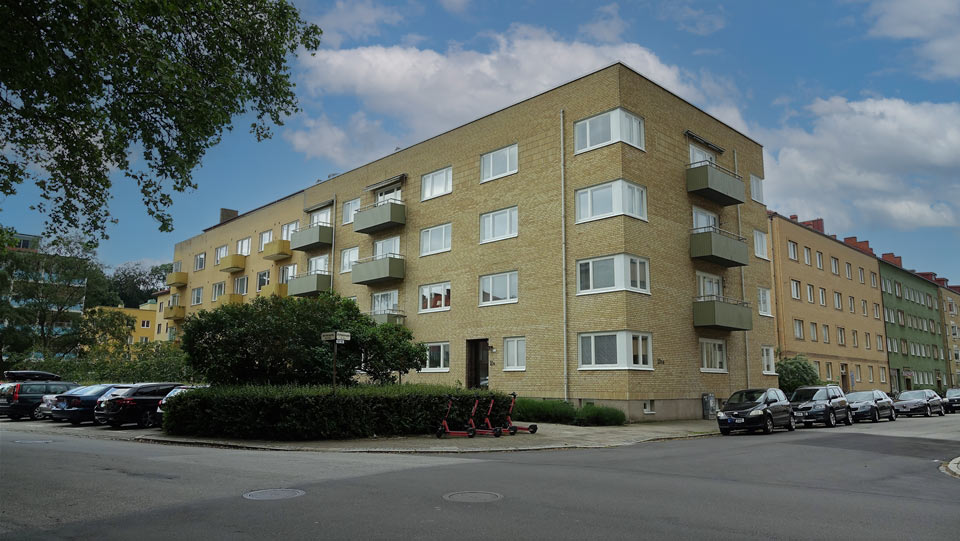 Flerbostadshus i tre våningar med gul tegelfasad. Tillhör BRF Åsbo.